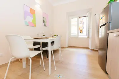 a kitchen and dining room with a white table and chairs at Domus Degli Dei in Rome