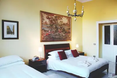 a bedroom with two beds and a painting on the wall at Bed and Breakfast Piazza Vittorio87 in Rome