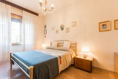 a bedroom with a bed and a table and a chandelier at family home in Rome