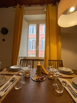 a dining room table with a candle and glasses at CasAlice Apartment Trastevere in Rome