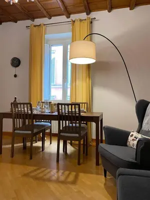 a living room with a table and chairs and a lamp at CasAlice Apartment Trastevere in Rome