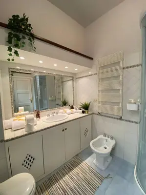 a bathroom with two sinks and a toilet and a mirror at CasAlice Apartment Trastevere in Rome