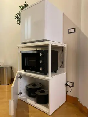 a white cabinet with a microwave on top of it at CasAlice Apartment Trastevere in Rome