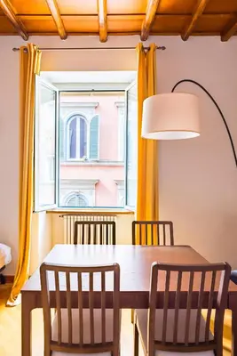 a dining room with a table and chairs and a window at CasAlice Apartment Trastevere in Rome
