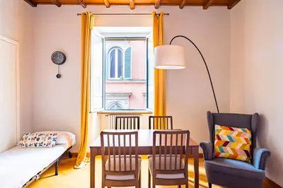 a dining room with a table and chairs and a window at CasAlice Apartment Trastevere in Rome