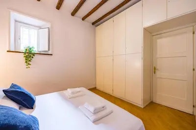 a bedroom with a white bed and a window at CasAlice Apartment Trastevere in Rome