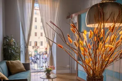 a vase with flowers in a living room with a lamp at Navona Charming Balcony in Rome