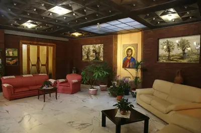 a living room with couches and tables and paintings at Casa Piccole Ancelle di Cristo Re in Rome