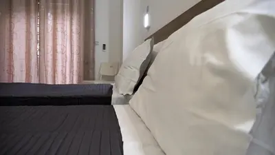 a bedroom with two beds with white pillows at Tiburtina Royal Suites in Rome