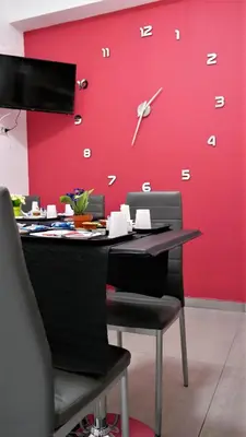 a desk with a clock on a red wall at Tiburtina Royal Suites in Rome