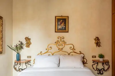 a bedroom with a bed with white sheets and a picture on the wall at iFlat Golden Gem in Trevi in Rome