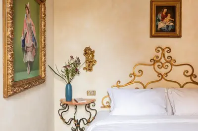 a bedroom with a bed and a vase with flowers at iFlat Golden Gem in Trevi in Rome
