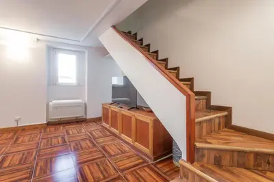 a staircase in a home with wooden flooring at Trastevere San Calisto 3 BDR Apartment in Rome