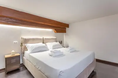 a bedroom with a large white bed with two towels on it at Trastevere San Calisto 3 BDR Apartment in Rome