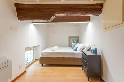 a bedroom with a bed and a dresser at Trastevere San Calisto 3 BDR Apartment in Rome