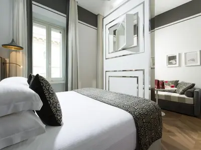 a bedroom with a white bed and a fireplace at Corso 281 Luxury Suites in Rome
