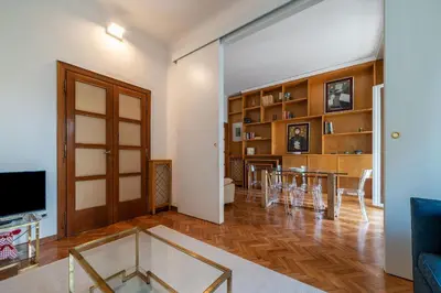 a living room with a table and chairs and a television at GuestHost - Sapienza & Villa Borghese Comfy Apartment in Rome
