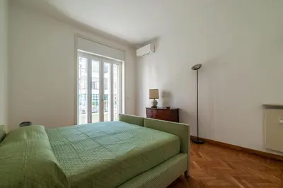 a bedroom with a green bed and a window at GuestHost - Sapienza & Villa Borghese Comfy Apartment in Rome