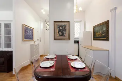 a dining room with a wooden table with chairs at Ripetta Beauty House in Rome
