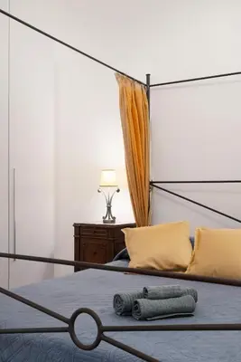 a bedroom with a canopy bed with yellow pillows at Ripetta Beauty House in Rome