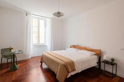 a white bedroom with a bed and a window at Lunaria Apartment Vatican Rome in Rome