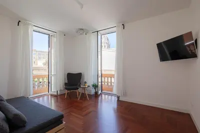 a living room with a couch and a chair and windows at Lunaria Apartment Vatican Rome in Rome