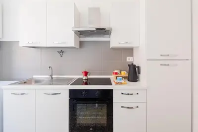 a kitchen with white cabinets and a sink at Lunaria Apartment Vatican Rome in Rome