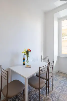 a white table with chairs and a vase with flowers at Lunaria Apartment Vatican Rome in Rome