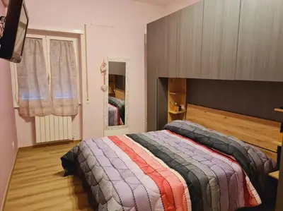 a bedroom with a large bed with a colorful blanket at Casa Sorelle Marchisio in Rome