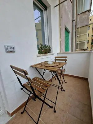 a table and chairs on a balcony with a window at La casa di Eurialo in Rome