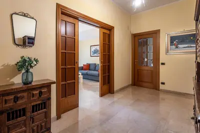 a living room with a blue couch and orange pillows at La Dimora del Vagamondo - ingresso in comune in Rome