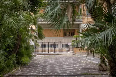 a gate in front of a building with palm trees at La Dimora del Vagamondo - ingresso in comune in Rome