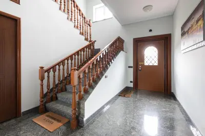 a hallway with stairs and a wooden door at Castelbarco House A in Rome