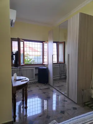 an empty room with a table and some windows at Castelbarco House A in Rome