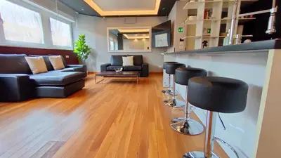 a living room with a bar and black stools at Auditorium Deluxe in Rome