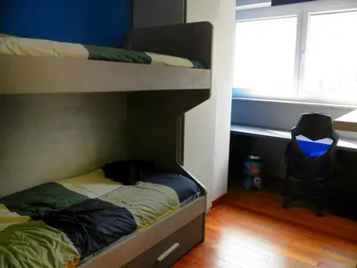 a bedroom with two bunk beds and a chair at Auditorium Deluxe in Rome