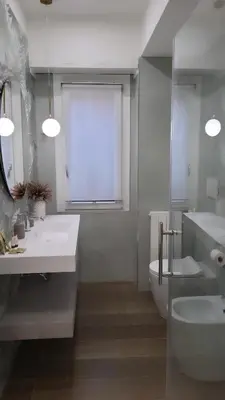a bathroom with two sinks and a toilet and a window at Buongiorno al Vaticano in Rome