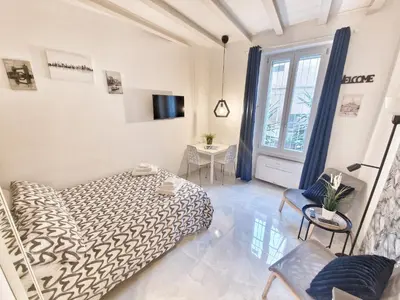 a white bedroom with a bed and a tv at Tiber Apartment in Trastevere in Rome