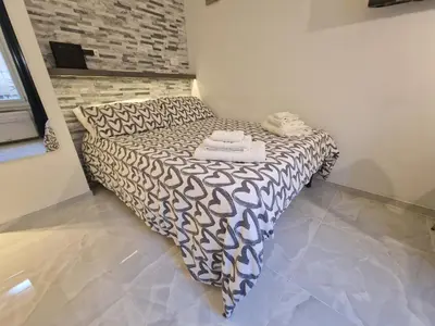 a bedroom with a black and white bed with towels on it at Tiber Apartment in Trastevere in Rome