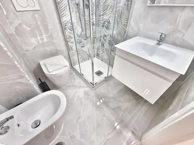 a white bathroom with a sink and a shower at Tiber Apartment in Trastevere in Rome