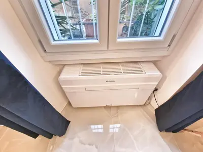 a air conditioner in a room with two windows at Tiber Apartment in Trastevere in Rome