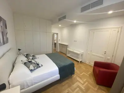 a bedroom with a bed and a red chair at Colosseum Rome Guest House Luil in Rome