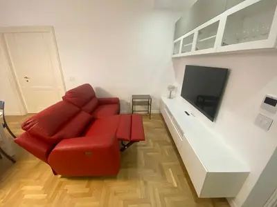 a living room with a red couch and a flat screen tv at Colosseum Rome Guest House Luil in Rome