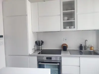 a white kitchen with white cabinets and a sink at Colosseum Rome Guest House Luil in Rome