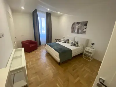 a bedroom with a bed and a red chair at Colosseum Rome Guest House Luil in Rome
