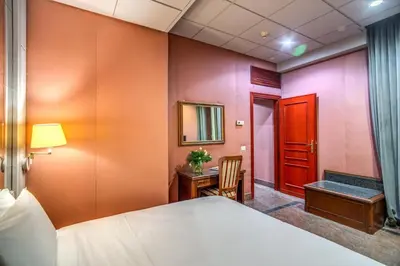 a hotel room with a bed and a desk and a mirror at Castro Pretorio 64 Easy Rooms in Rome