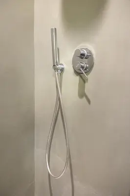 a shower head is attached to a wall at Best Room Catone 21 in Rome