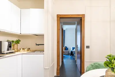 a kitchen with white cabinets and a hallway at Best Room Catone 21 in Rome