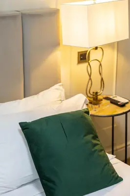 a green pillow sitting on a bed next to a table at Best Room Catone 21 in Rome