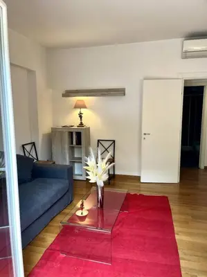 a living room with a blue couch and a red rug at St. Peter Home Private Terrace in Rome
